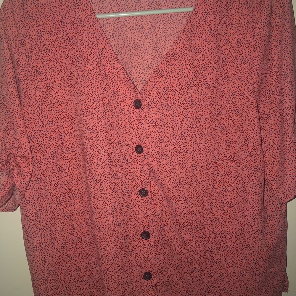 Pink button up shirt with black speckles.